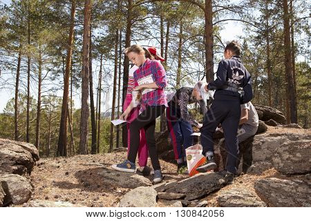 RUSSIA, ULAN-UDE - MAY 22, 2016: Russian Azimut - 2016. Orienteering competition is held annually in the Buryatia region. People at at control point at orienteering course.