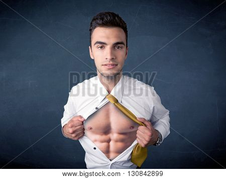 Businessman tearing off his shirt and showing mucular body concept on background