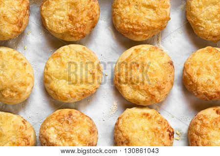 Hungarian traditional Cheese Pogacsa savory baked bread-like pastry photographed overhead with natural light (Selective Focus Focus on the top of the pastries)