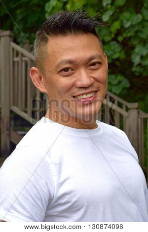Mature Asian Man smiling happily posing outdoor