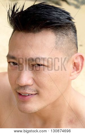 Asian Man posing outdoor topless looking at the camera