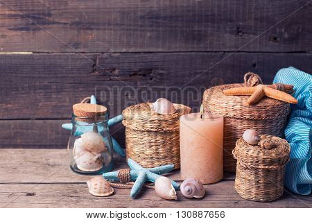 Сandle and marine items on aged wooden background. Sea objects on wooden planks. Selective focus.Toned image.