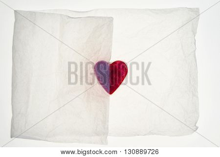 Heart shaped object partially covered by packaging tissue