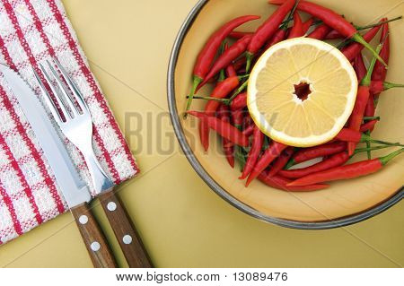Composición de limón, ají, servilleta y cubiertos