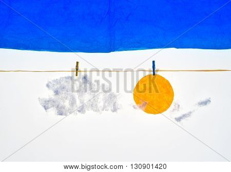 composition with clothes pegs and a fake sun and sky