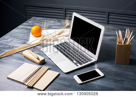 Creative designer desktop with blank smart phone and laptop screens stationery wheat spikes orange and construction sketch. Mock up