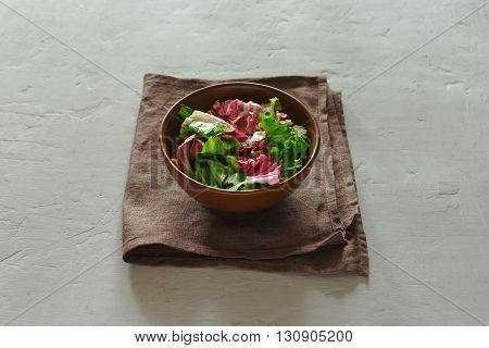 bowl of fresh salad on a white surface. Concept helpful and simple food