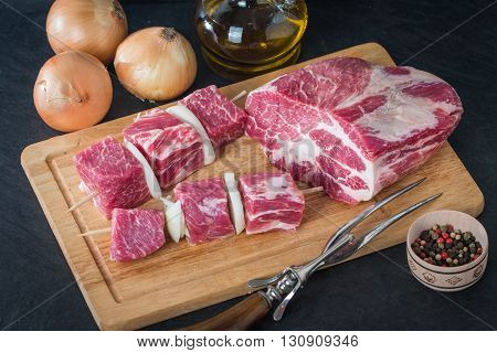 Raw pork meat cut into cubes ready for bbq kebab on black background