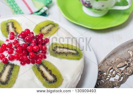 Cake with cream kiwi and kalina  on white wooden table