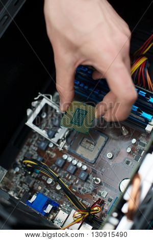 Computer technician installing CPU into the motherboard.