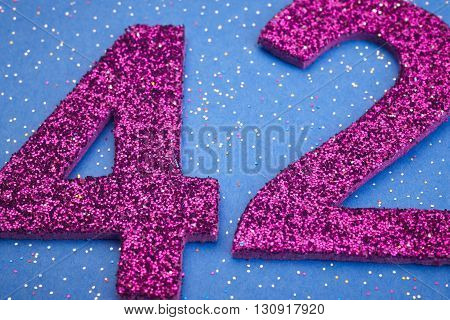 Number fortytwo purple color over a blue background. Anniversary. Horizontal