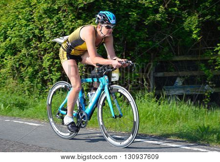 Grafham, Cambridgeshire, England - May 22, 2016:  Close up of Female triathlete on road cycling stage.