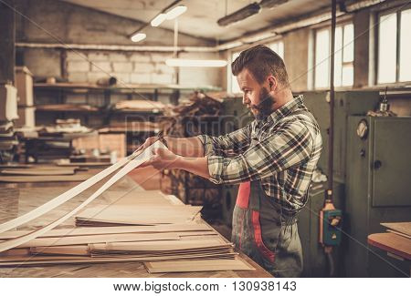 Carpenter doing his job in carpentry workshop.