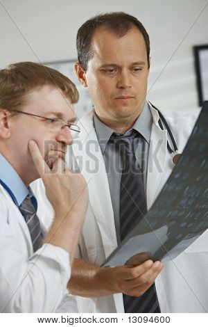 V ordinaci - středního věku mužského lékaři mají konzultace nad tomograf prohledávání počítače.