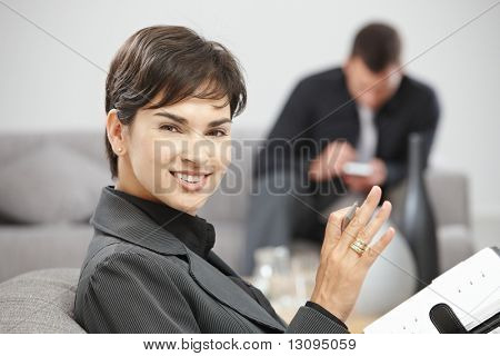 在写入个人管理器时，注意到办公室坐在软的快乐年轻女商人微笑。