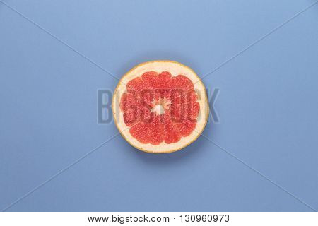 Photo kinds of pop art. Grapefruit on a blue paper texture background in the centr of photo