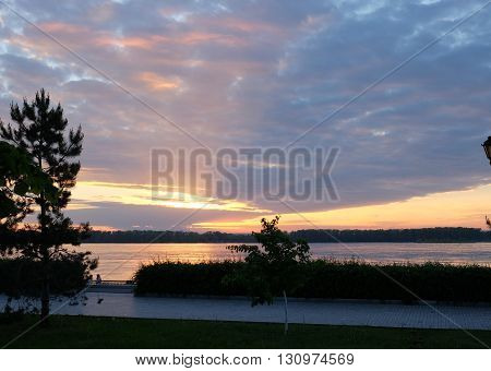 Sunset cuts through the clouds over the river Volga in Samara