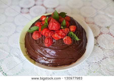 Brown chocolate cake decorated with red strawberries