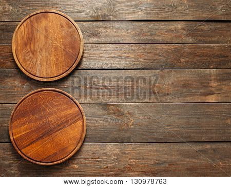 Two empty wooden pizza plates on the wooden table. Vertical line. Flat lay of empty wooden pizza plates. Free space. Sidepiece