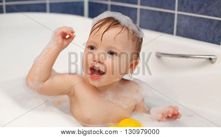 Baby in the bathroom with foam bath