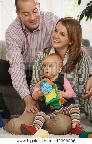 Üç birlikte oturma odasında otururken mutlu bir aile portresi.