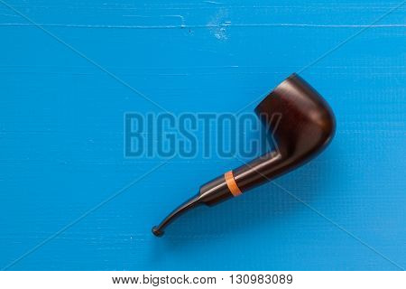 Luxury tobacco pipe on the wooden blue table