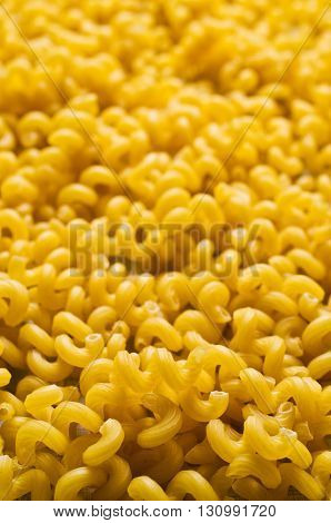Background of dry pasta cavatappi. Selective focus.