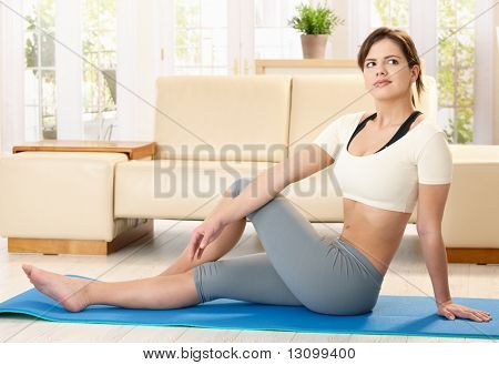 Mädchen, die Übungen auf PU-Matte im Wohnzimmer.