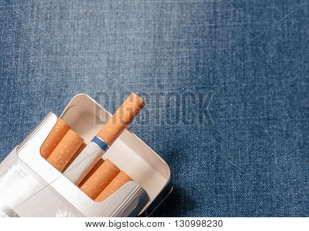 Closeup to jeans pocket with cigarettes. Cigarettes in blue denim