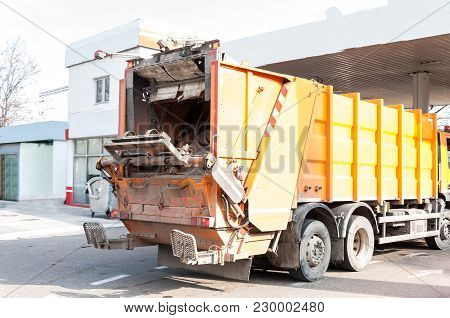 Rear End Of Garbage Dumper Truck On The Way To Waste Dumpster Cans Ready To Collect Litter And Junk 