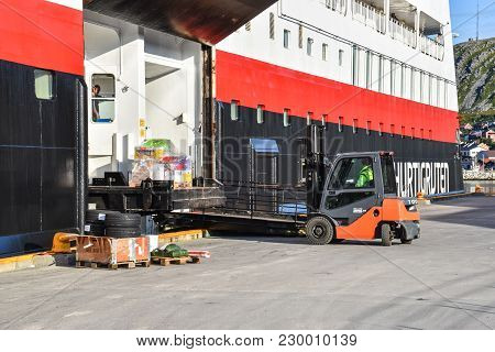 08-19-2017 Finnmark, Norway: Loading And Unloading Of Goods On Hurtigruten Packet Ship