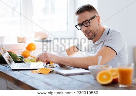 Advices For Biohacking. Handsome Man Verifying His Note With Article From Internet While Stretching 