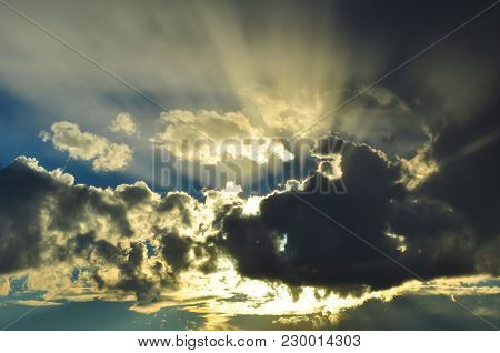 Raylights From The Sun Behind Clouds In A Morning Sky.