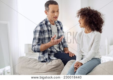 My Dear Child. Attractive Inspired Dark-haired Man Smiling And Talking With His Daughter And They Lo