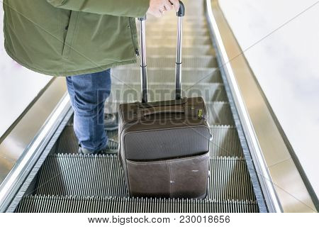 Man Traveling By Airplane. Hand Of The Passenger With Luggage On The Escalator At The Airport