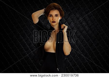 Sexy Lady With Beautiful Silicon Breasts In Black Jacket Looks At The Camera Isolated On White Backg