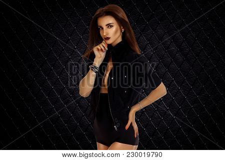 Portrait Of A Beautiful Sexual Girl With Dark Lipstick And A Black Suit That Poses On Camera Isolate