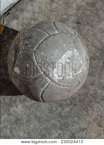 Worn-out Soccer Ball On Concrete In The Sun