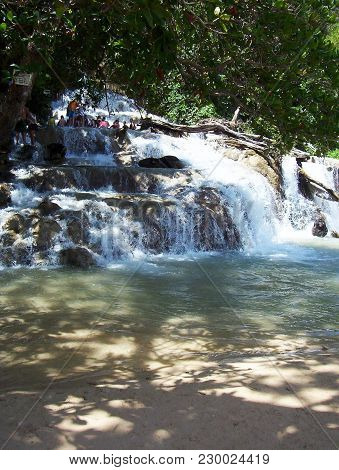 Cascading Tropical Waterfall On A Shading Beachfront In Jamaica