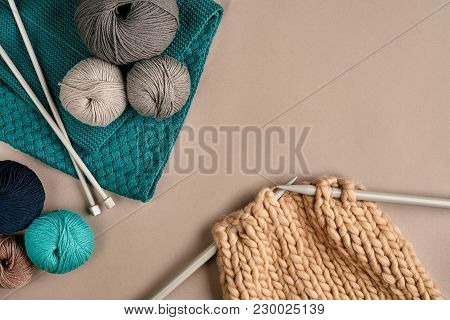 Grey And Turquoise Balls Wool And Knitting On Needles On Beige Background. Knitting As A Kind Of Nee