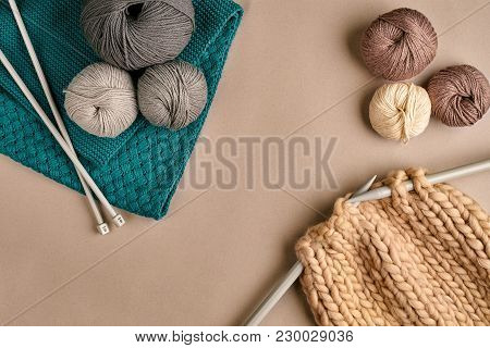 Grey And Brown Ball Wool And Knitting On Needles On Beige Background. Knitting As A Kind Of Needlewo