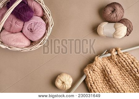 Pink And Brown Ball Wool And Knitting On Needles On Beige Background. Knitting As A Kind Of Needlewo