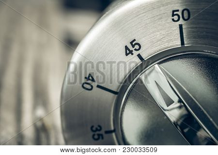 45 Minutes - Three-quartes Of An Hour - Macro Of An Analog Chrome Kitchen Timer On Wooden Table