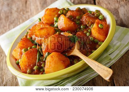Home Indian Food: Aloo Matar - Potatoes, Green Peas And Spicy Sauce Closeup. Horizontal