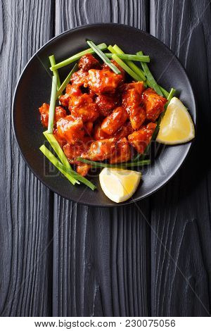 Indian Chicken 65 With Sauce And Green Onions And Lemon Close-up On The Table. Vertical Top View