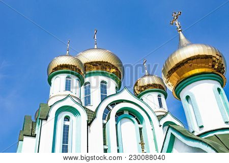 White church with gold domes a part of the European architecture. Russian orthodox church with typical golden onion domes