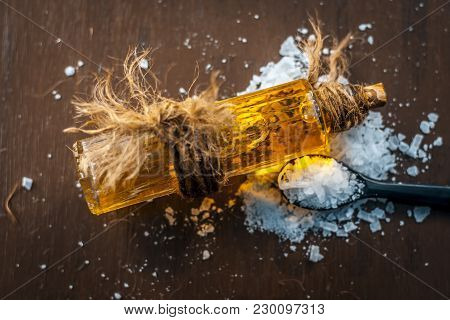 Close Up Of Aurvedic Herb Camphor Powder In A Small Spoon And Its Oil On Brown Wooden Surface In Dar