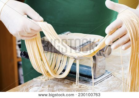 Process Of Production Of  Pasta. Fresh Pasta And Pasta Machine On Kitchen Table