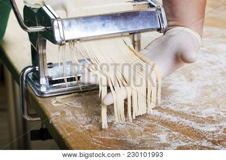 Process Of Production Of  Pasta. Fresh Pasta And Pasta Machine On Kitchen Table