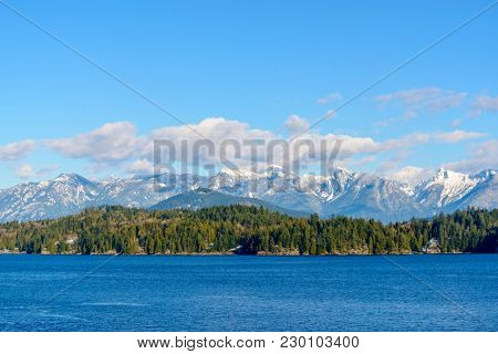 Fantastic view over ocean, snow mountain and rocks at Sechelt inlet in Vancouver, Canada.